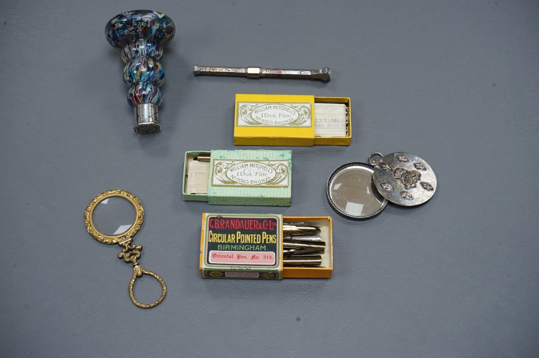 A small collection of objects to include a 17th century? French multi-cane glass seal, miniature white metal mirror and boxed pen nibs, seal 8cm high